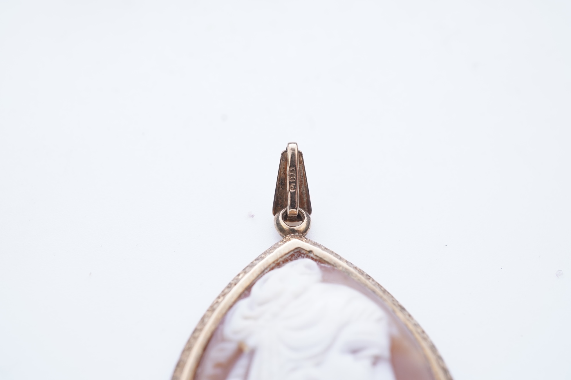 A collection of four rings and a pendant